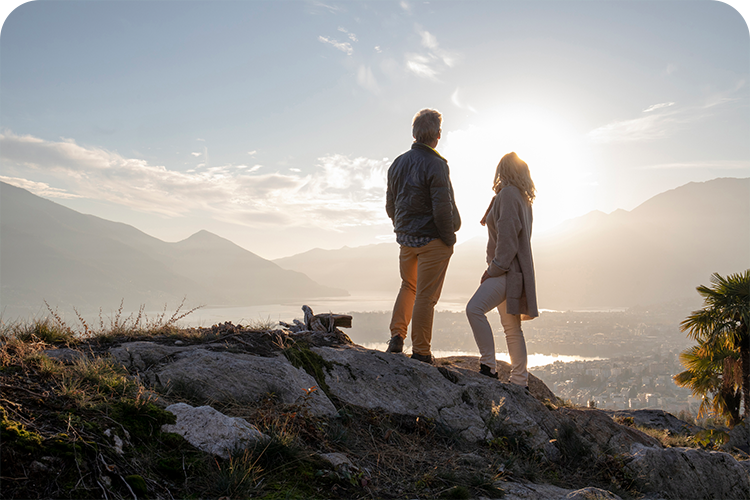 Couple on hill top looking out at lake