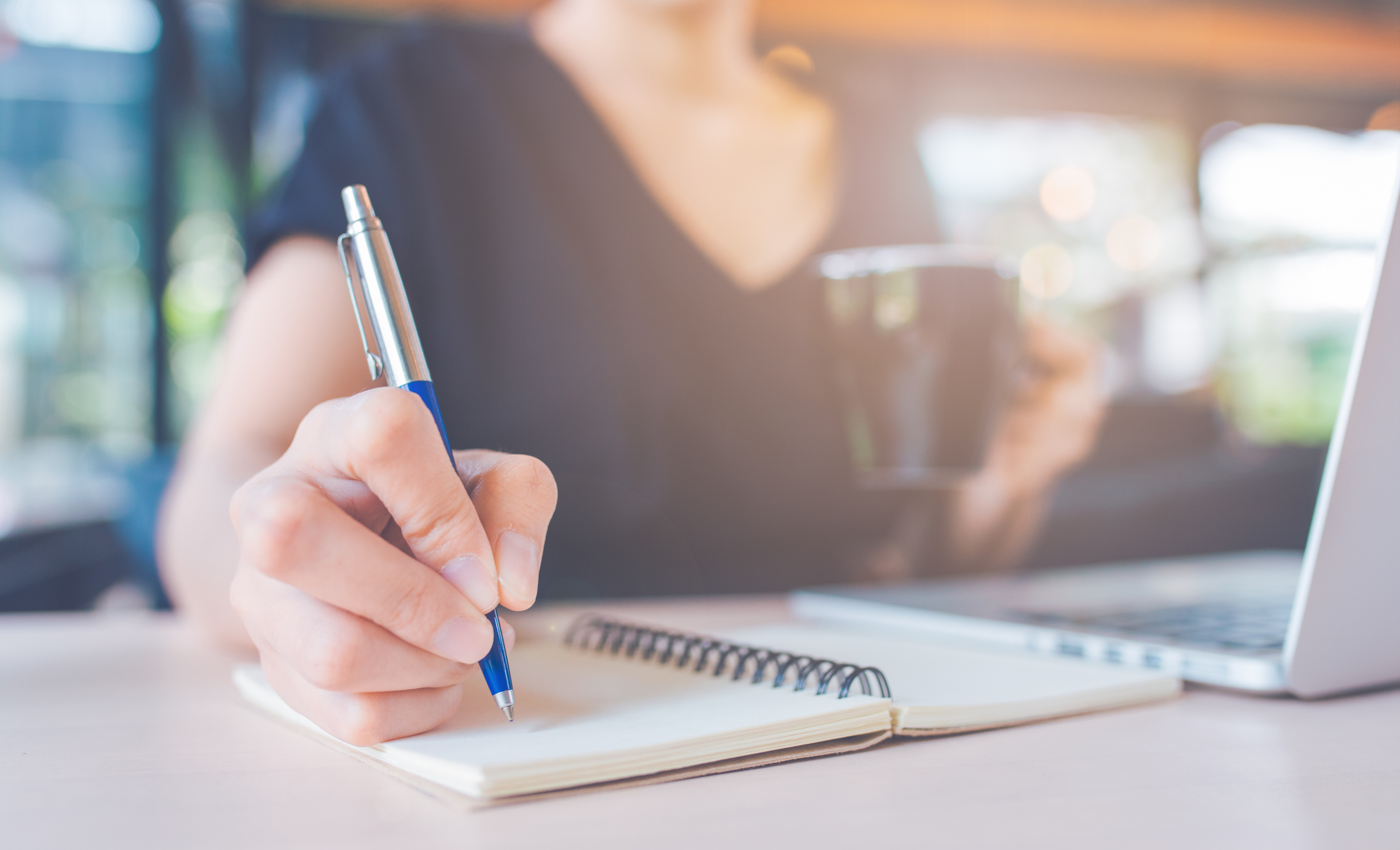 Woman watching webinar and taking notes