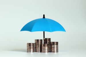A pile of coins with an open blue umbrella.